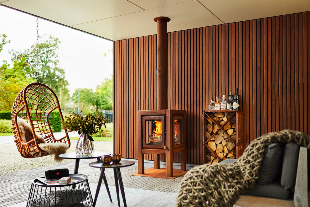 Photo of a large scandinavian patio in Amsterdam with with fireplace and a pergola.