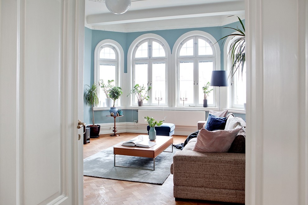 This is an example of a mid-sized traditional formal living room in Malmo with blue walls and medium hardwood floors.