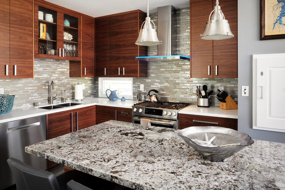 Design ideas for a mid-sized beach style l-shaped open plan kitchen in San Diego with an undermount sink, flat-panel cabinets, medium wood cabinets, granite benchtops, grey splashback, glass tile splashback, stainless steel appliances, porcelain floors, with island and brown floor.