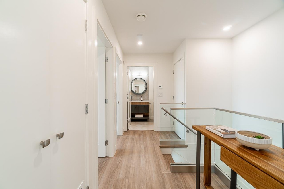 Inspiration for a mid-sized laminate floor and brown floor hallway remodel in Vancouver with white walls