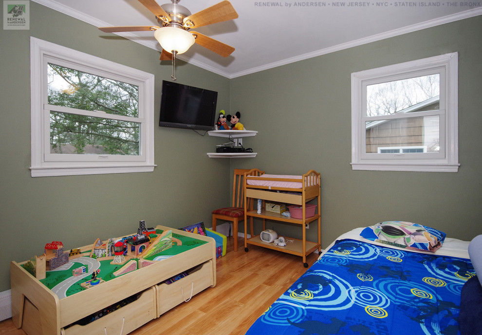 На фото: нейтральная детская среднего размера с спальным местом, зелеными стенами и светлым паркетным полом для ребенка от 1 до 3 лет с