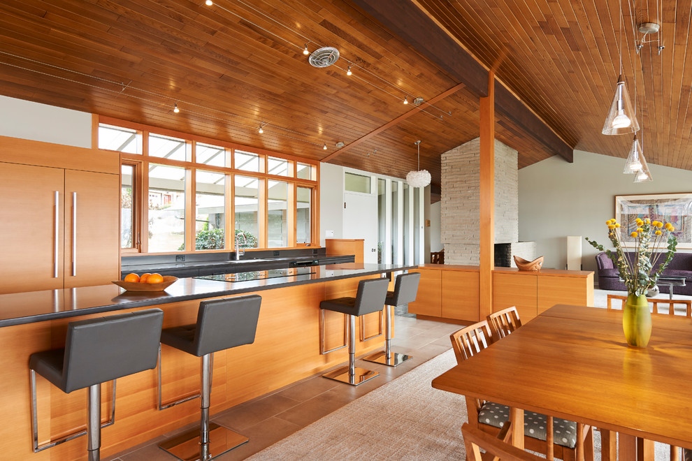 Large midcentury open plan dining in Seattle with carpet, a brick fireplace surround and beige floor.