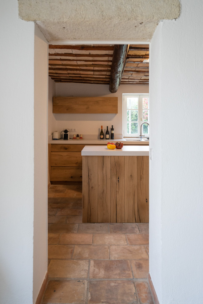 Small transitional l-shaped separate kitchen in Other with an undermount sink, beaded inset cabinets, light wood cabinets, quartz benchtops, metallic splashback, metal splashback, black appliances, terra-cotta floors, with island, pink floor and white benchtop.