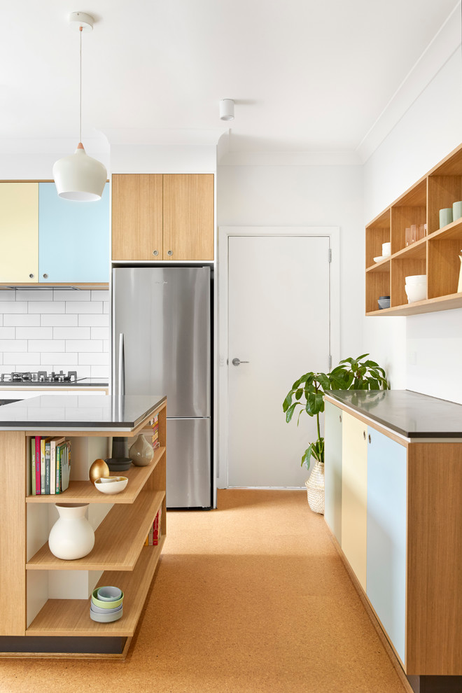 Large scandinavian galley kitchen pantry in Melbourne with a drop-in sink, beaded inset cabinets, medium wood cabinets, concrete benchtops, white splashback, subway tile splashback, stainless steel appliances, cork floors and with island.