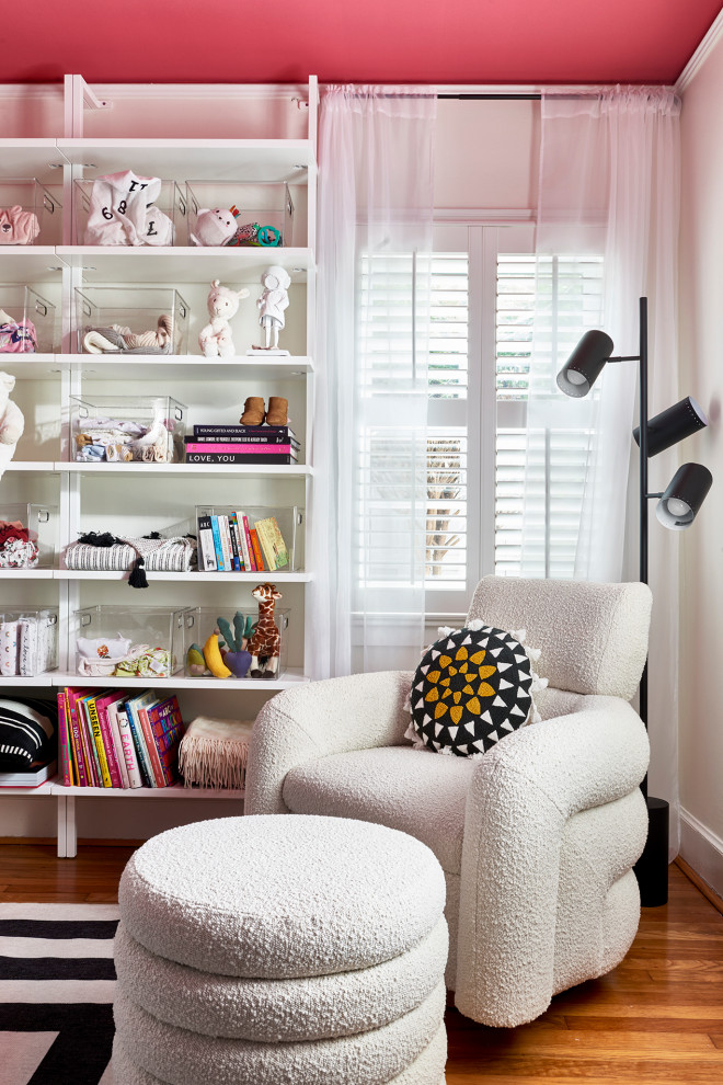 Immagine di una piccola cameretta per neonata moderna con pareti bianche e pavimento in legno massello medio