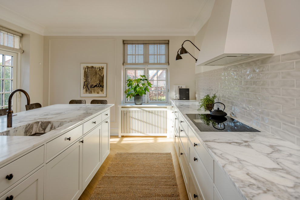 Country kitchen in Odense with a single-bowl sink, shaker cabinets, white cabinets, marble worktops, an island and multicoloured worktops.