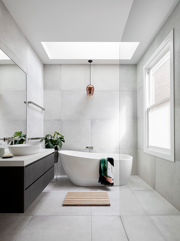 Photo of a mid-sized contemporary master bathroom in Melbourne with flat-panel cabinets, dark wood cabinets, a freestanding tub, gray tile, engineered quartz benchtops, grey floor, an open shower, a curbless shower and a vessel sink.