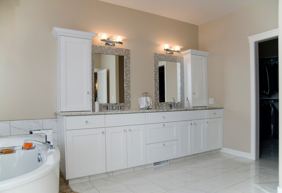 Design ideas for a contemporary master bathroom in Calgary with shaker cabinets, white cabinets, granite benchtops, white tile, stone tile, a freestanding tub, a corner shower, a two-piece toilet, an undermount sink, beige walls and ceramic floors.