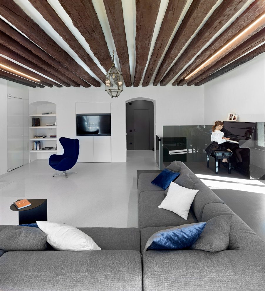 Пример оригинального дизайна: огромная изолированная гостиная комната в современном стиле с музыкальной комнатой, белыми стенами, фасадом камина из камня, серым полом и балками на потолке
