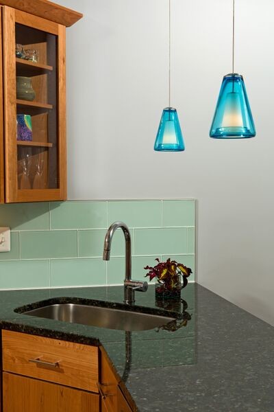 Eat-in kitchen - mid-sized transitional u-shaped medium tone wood floor eat-in kitchen idea in DC Metro with a single-bowl sink, flat-panel cabinets, medium tone wood cabinets, granite countertops, blue backsplash, glass tile backsplash, stainless steel appliances and a peninsula