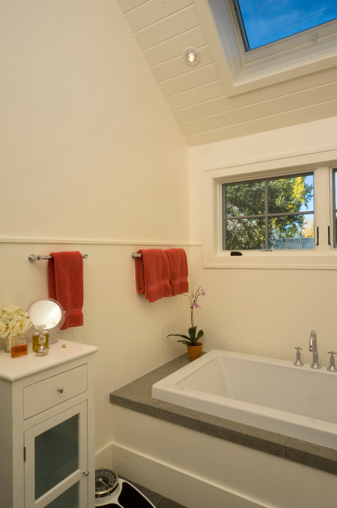 This is an example of a country master bathroom in Denver with flat-panel cabinets, white cabinets, an alcove tub and white walls.
