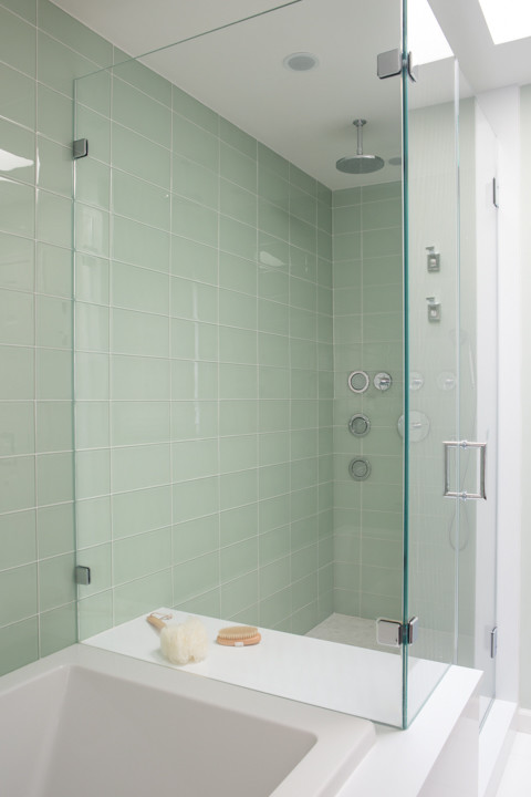 Idee per una grande stanza da bagno design con ante lisce, ante in legno scuro, vasca da incasso, doccia alcova, piastrelle verdi, piastrelle in pietra, pareti verdi e pavimento in marmo