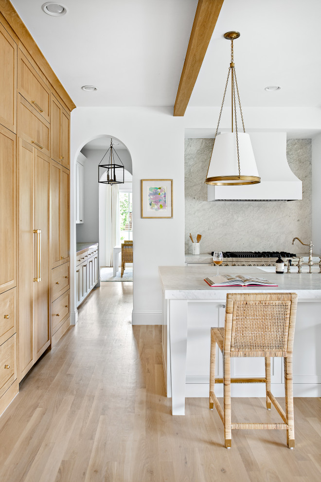 Open concept kitchen - large transitional l-shaped light wood floor, brown floor and exposed beam open concept kitchen idea in Dallas with an undermount sink, shaker cabinets, white cabinets, marble countertops, white backsplash, marble backsplash, paneled appliances, an island and white countertops