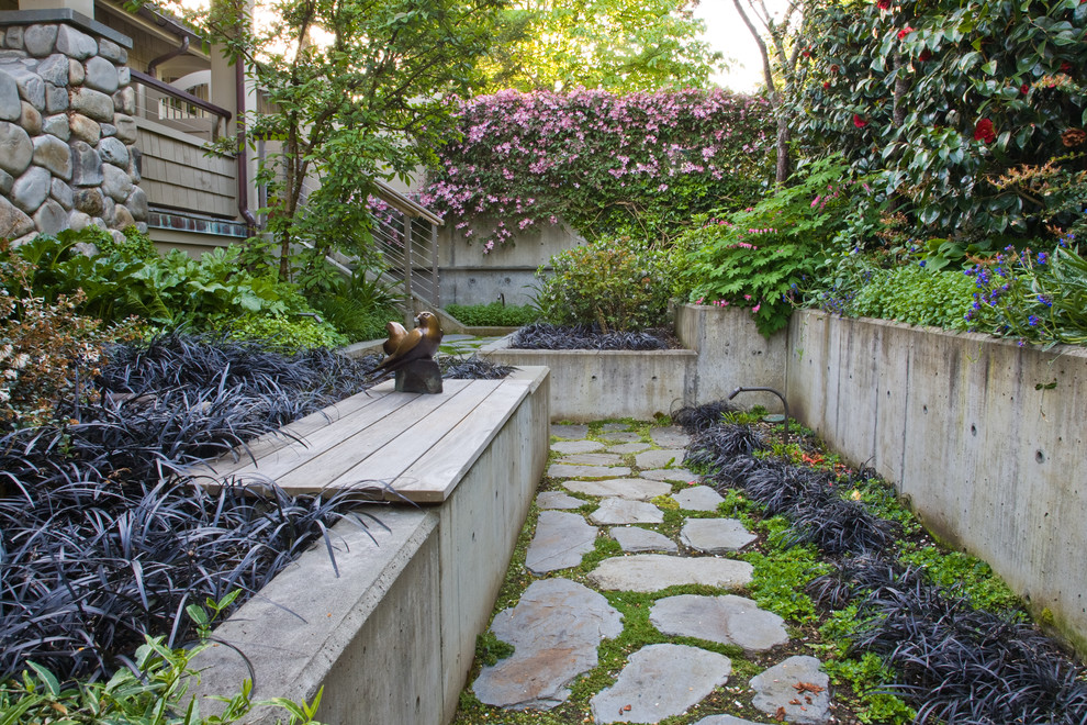 Inspiration for a mediterranean backyard garden in Seattle with a retaining wall and natural stone pavers.