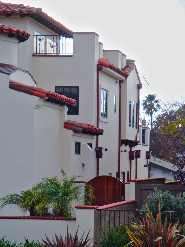 Large mediterranean three-storey stucco white house exterior in San Diego with a hip roof.