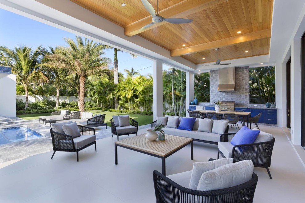 Beach style backyard patio in Miami with an outdoor kitchen and a roof extension.