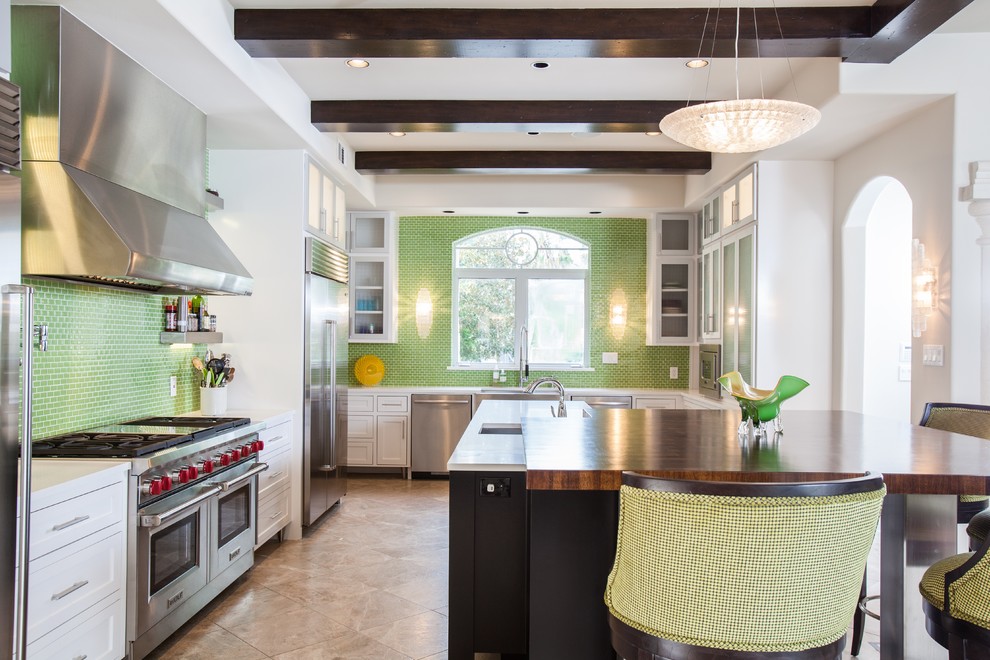 Design ideas for a transitional u-shaped kitchen in Houston with an undermount sink, shaker cabinets, white cabinets, green splashback, stainless steel appliances and multiple islands.