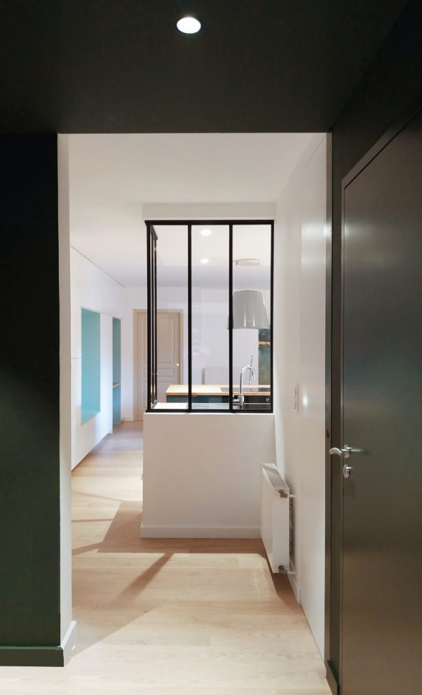 Réalisation d'un salon minimaliste de taille moyenne avec un mur vert, parquet clair et un sol beige.