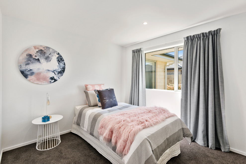 This is an example of a contemporary kids' room for girls in Christchurch with white walls, carpet and grey floor.