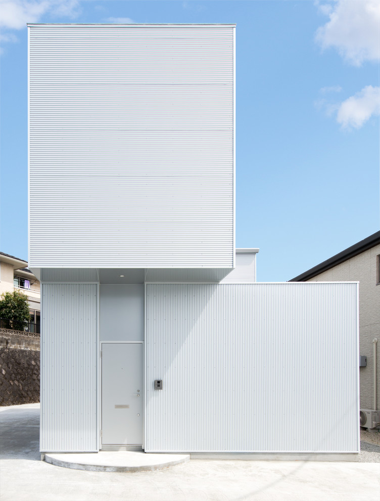 This is an example of a contemporary two-storey white exterior in Other with a flat roof.