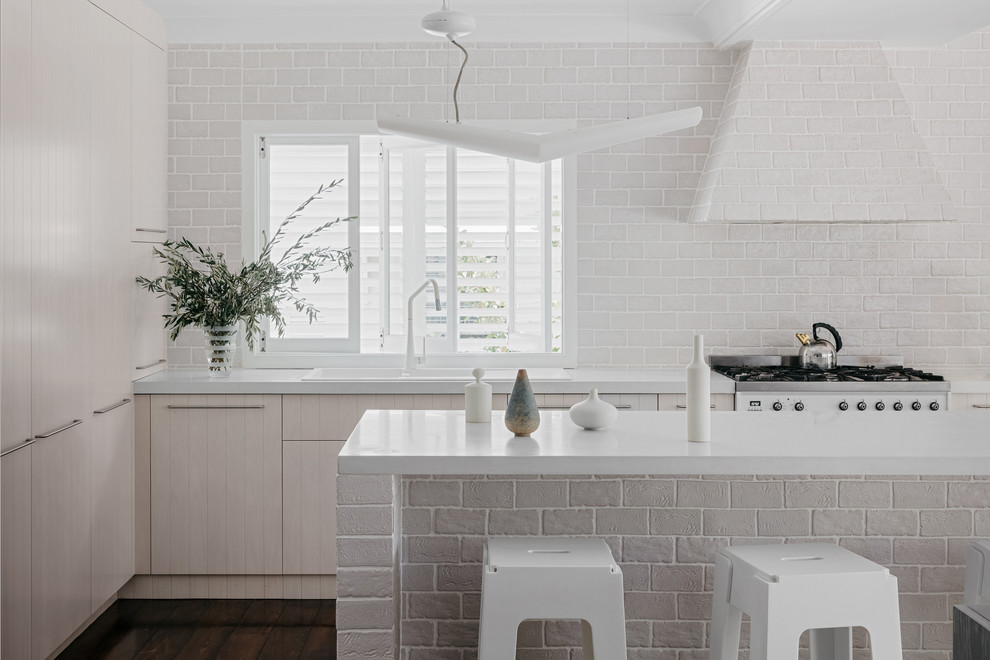 Design ideas for a large traditional galley eat-in kitchen in Brisbane with a double-bowl sink, raised-panel cabinets, light wood cabinets, concrete benchtops, grey splashback, porcelain splashback, white appliances, dark hardwood floors, with island, brown floor and white benchtop.