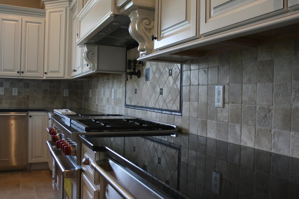 Kitchen - large transitional u-shaped travertine floor and beige floor kitchen idea with white cabinets, stainless steel appliances, raised-panel cabinets, solid surface countertops, beige backsplash and ceramic backsplash