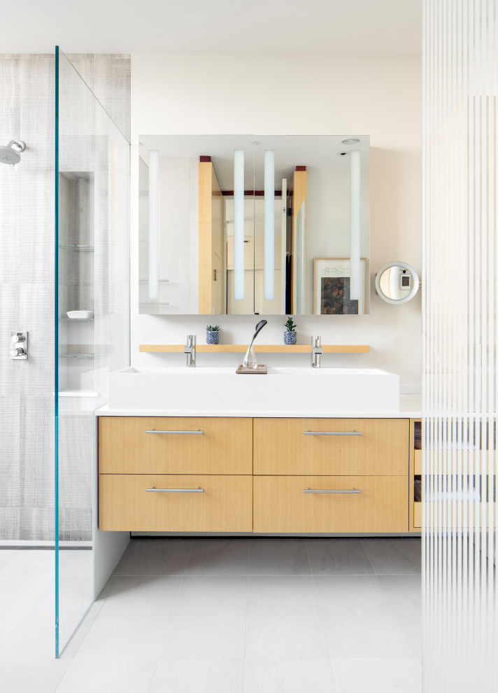 Inspiration for a mid-sized modern master bathroom in Boston with flat-panel cabinets, light wood cabinets, a japanese tub, an open shower, a one-piece toilet, gray tile, cement tile, white walls, concrete floors, a console sink, quartzite benchtops, grey floor, a hinged shower door and white benchtops.