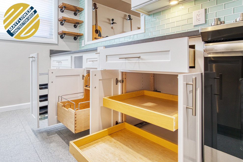 This is an example of a small modern galley kitchen/diner in DC Metro with a submerged sink, shaker cabinets, white cabinets, granite worktops, grey splashback, glass tiled splashback, stainless steel appliances, ceramic flooring, no island, grey floors and grey worktops.