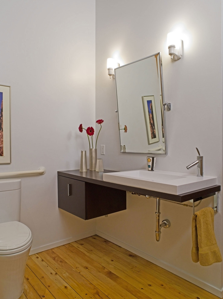 Mid-sized modern master bathroom in Seattle with flat-panel cabinets, dark wood cabinets, an alcove shower, a two-piece toilet, white tile, subway tile, white walls, light hardwood floors, an undermount sink and solid surface benchtops.