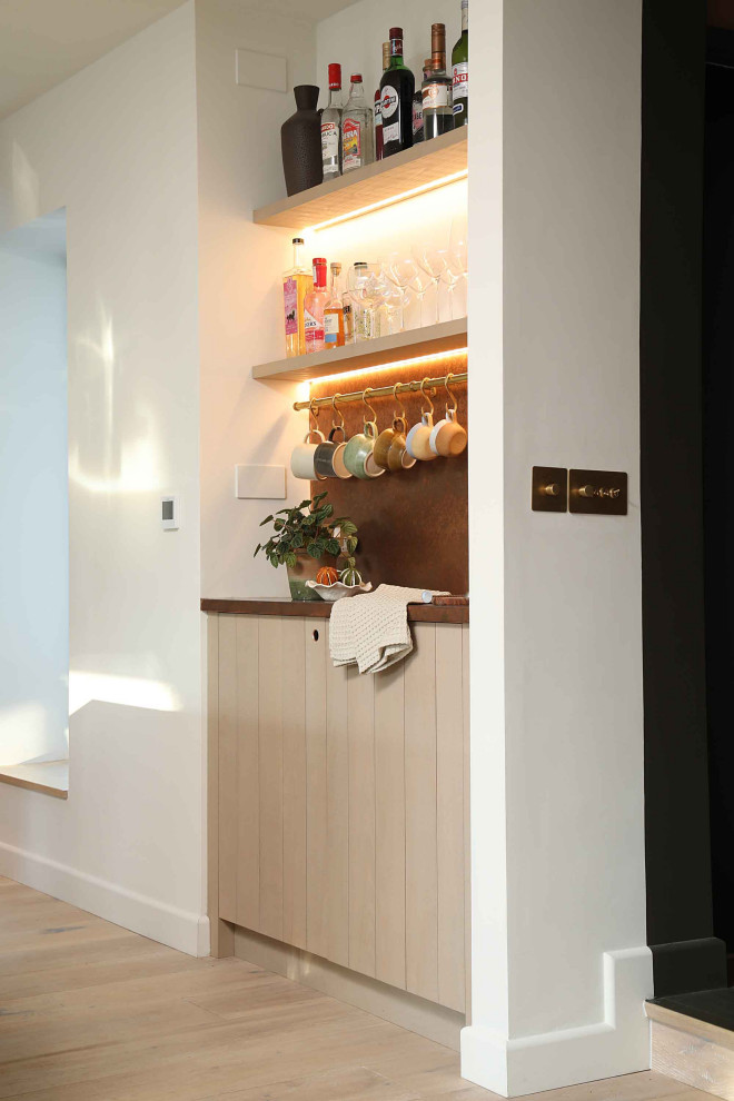 Esempio di un grande angolo bar con lavandino scandinavo con ante lisce, ante in legno chiaro, top in rame e parquet chiaro