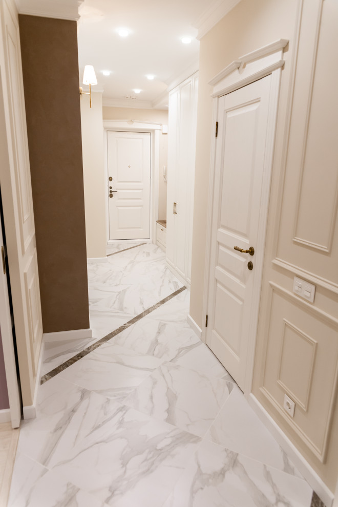 Photo of a mid-sized transitional hallway in Other with beige walls, porcelain floors and white floor.