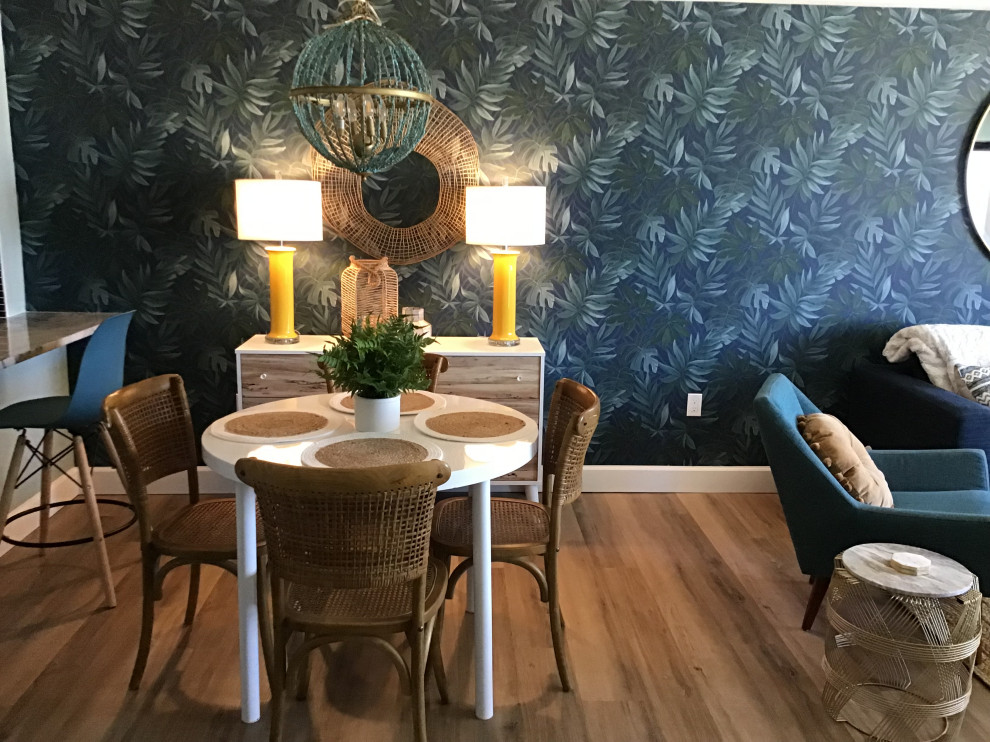 Photo of a mid-sized beach style open plan dining in Orlando with blue walls, vinyl floors, brown floor and wallpaper.