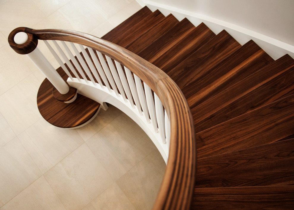Photo of a mid-sized traditional wood curved staircase in Buckinghamshire with wood risers and wood railing.