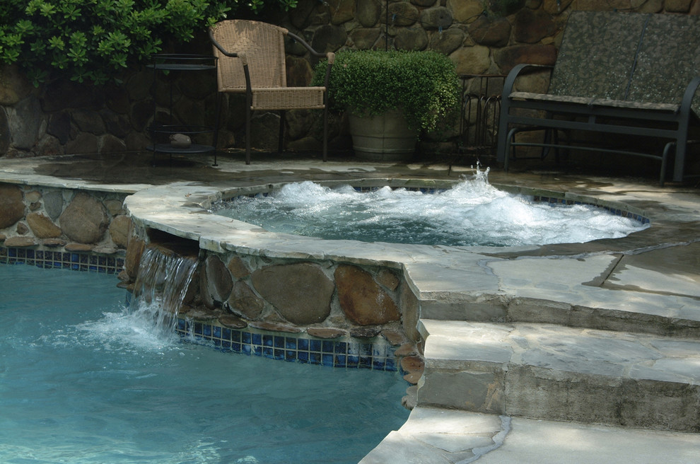 Example of a large mountain style backyard stone and custom-shaped natural hot tub design