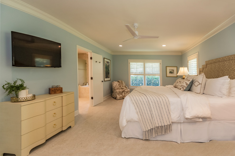 Large eclectic master bedroom in Tampa with blue walls, travertine floors and beige floor.