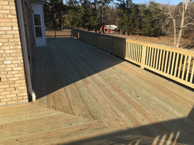 Example of a large mountain style side yard deck design in Atlanta with a roof extension