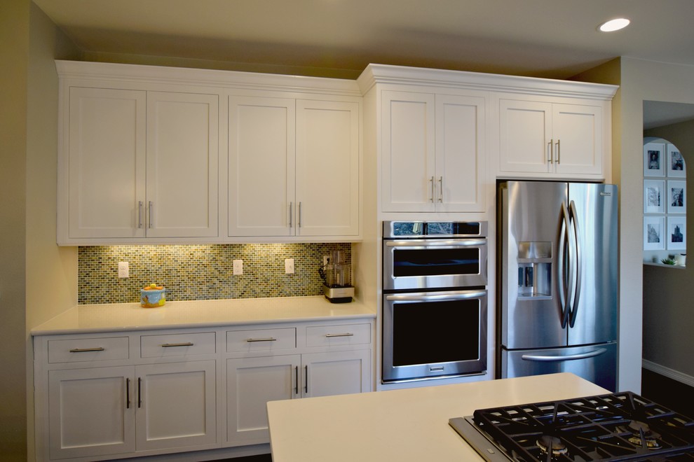 Photo of a large classic u-shaped kitchen/diner in Denver with a submerged sink, beaded cabinets, white cabinets, stainless steel appliances and no island.