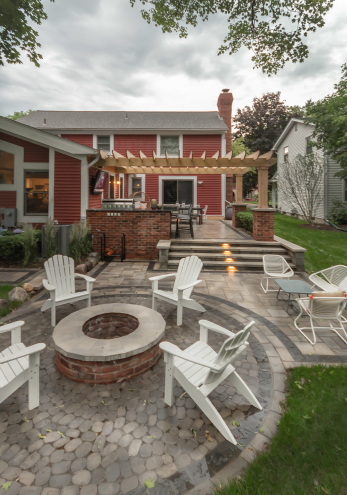 Design ideas for a small arts and crafts backyard patio in Detroit with a fire feature, brick pavers and a pergola.