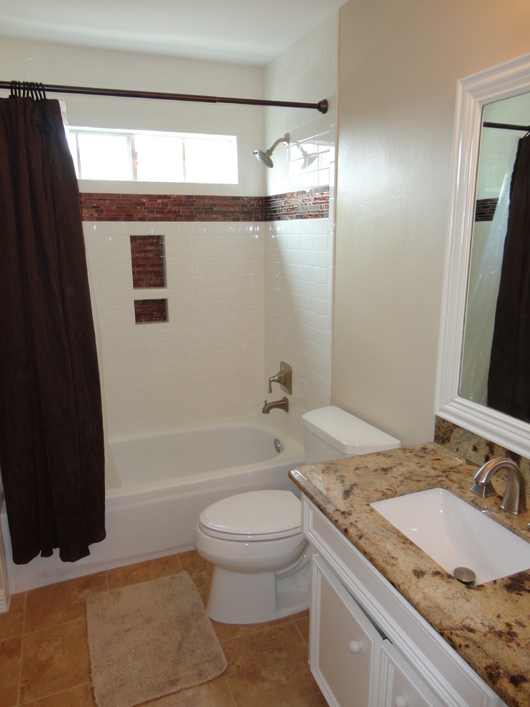 Design ideas for a mid-sized traditional kids bathroom in Houston with raised-panel cabinets, white cabinets, a corner tub, a shower/bathtub combo, a two-piece toilet, white tile, ceramic tile, beige walls, travertine floors, an undermount sink and granite benchtops.