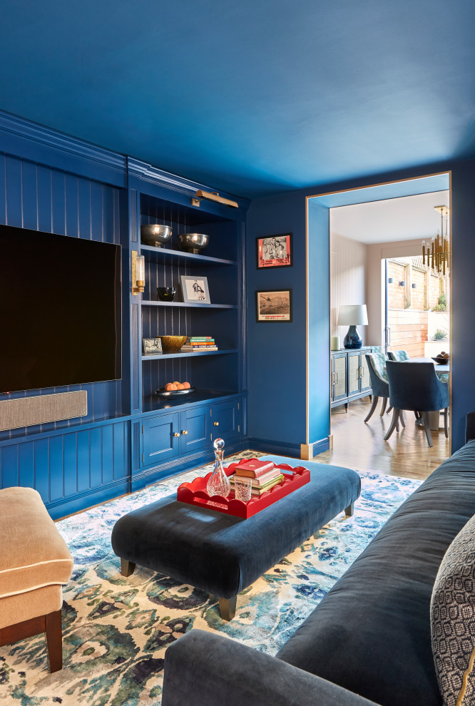 Источник вдохновения для домашнего уюта: изолированная гостиная комната в классическом стиле с синими стенами, паркетным полом среднего тона, телевизором на стене, коричневым полом и стенами из вагонки