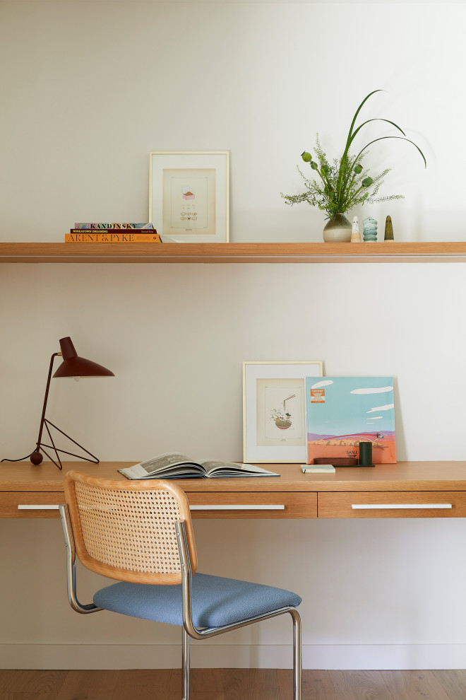 Example of a small trendy built-in desk light wood floor and brown floor home office design in San Francisco with white walls