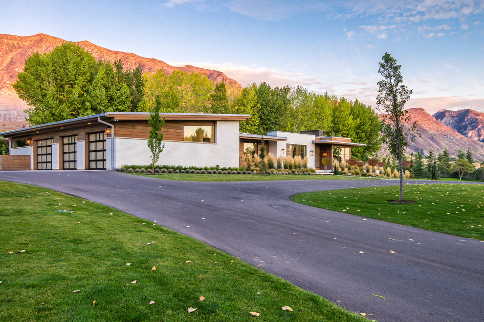 Expansive contemporary one-storey white house exterior in Salt Lake City with mixed siding and a shed roof.