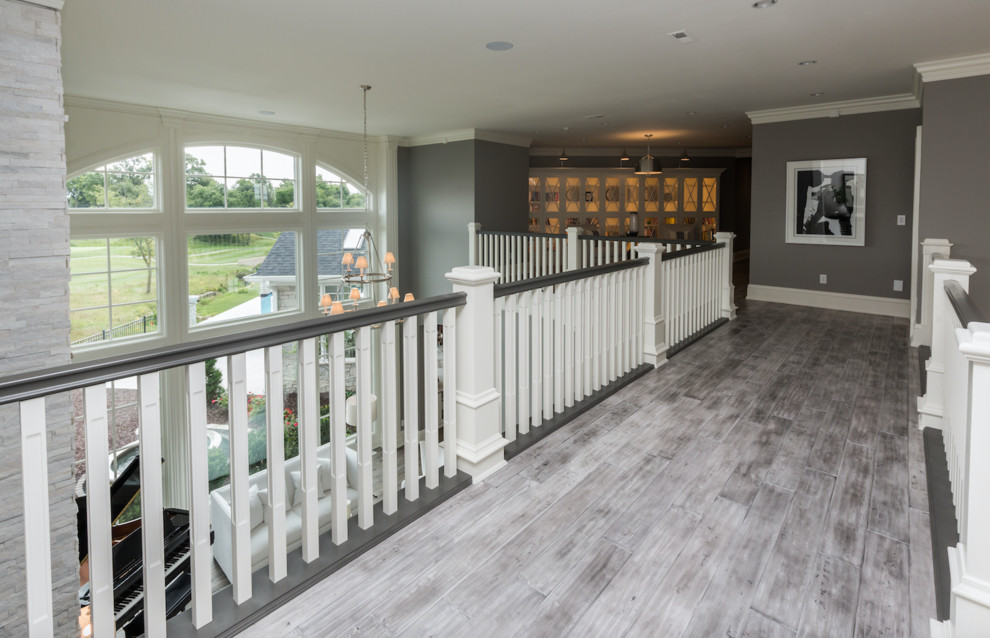 Photo of a mid-sized transitional hallway in Other with grey walls, painted wood floors and grey floor.