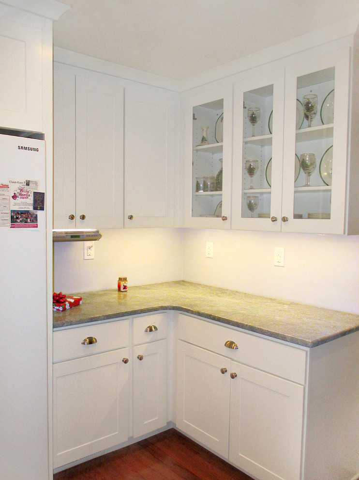 Example of a transitional l-shaped eat-in kitchen design with an undermount sink, shaker cabinets, white cabinets, granite countertops and white appliances