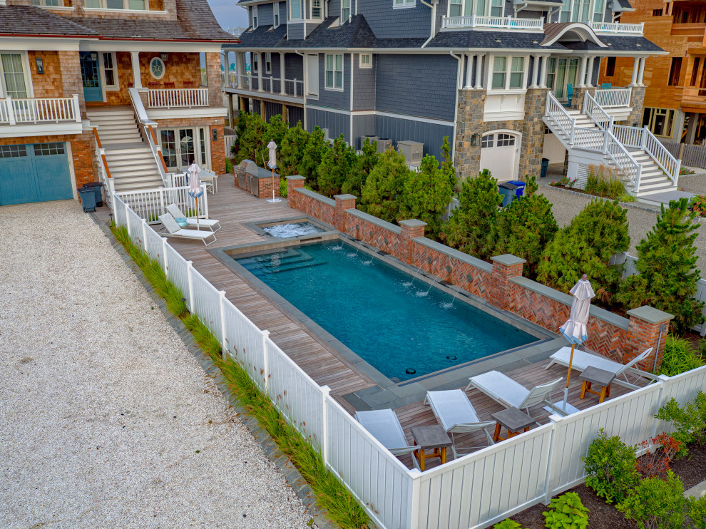 Photo of a mid-sized beach style front yard rectangular pool in New York with decking.