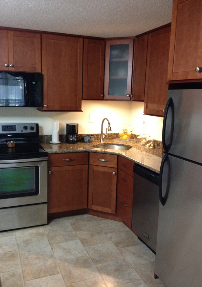 Inspiration for a small transitional l-shaped linoleum floor eat-in kitchen remodel in Boston with an undermount sink, recessed-panel cabinets, medium tone wood cabinets, granite countertops, stainless steel appliances and no island