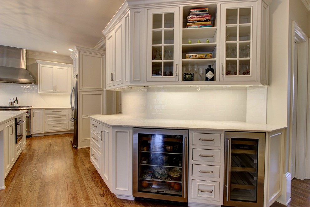 Kitchen pantry - large transitional u-shaped light wood floor kitchen pantry idea in Atlanta with an undermount sink, recessed-panel cabinets, white cabinets, quartz countertops, white backsplash, subway tile backsplash, stainless steel appliances and an island