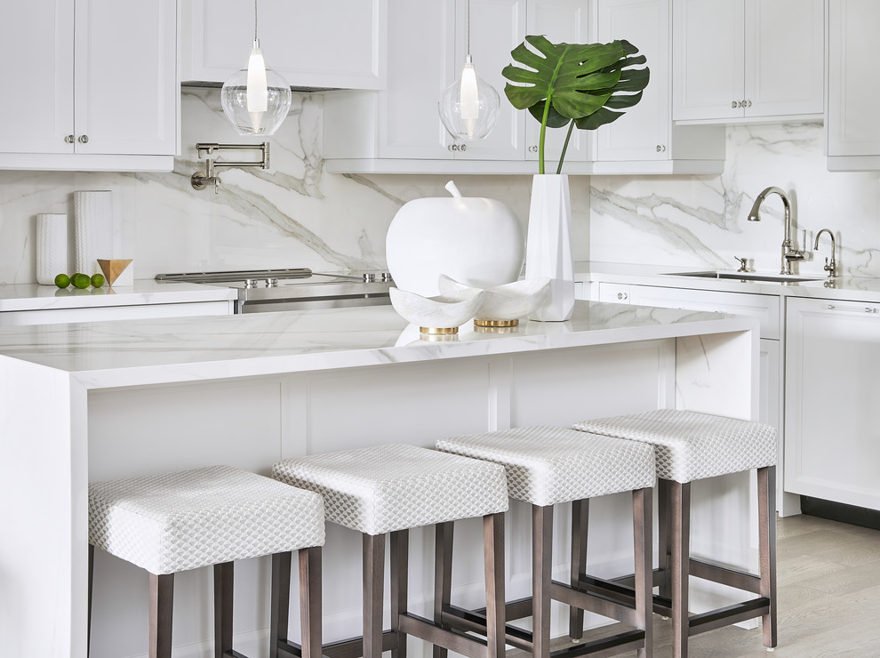 Transitional l-shaped light wood floor and beige floor kitchen photo in Toronto with an undermount sink, recessed-panel cabinets, white cabinets, white backsplash, paneled appliances, an island and white countertops