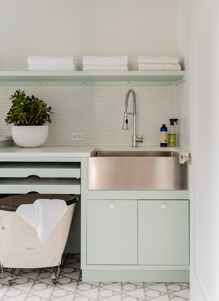 Design ideas for a mid-sized contemporary dedicated laundry room in New York with a farmhouse sink, flat-panel cabinets, green cabinets, quartzite benchtops, white walls, ceramic floors and grey floor.