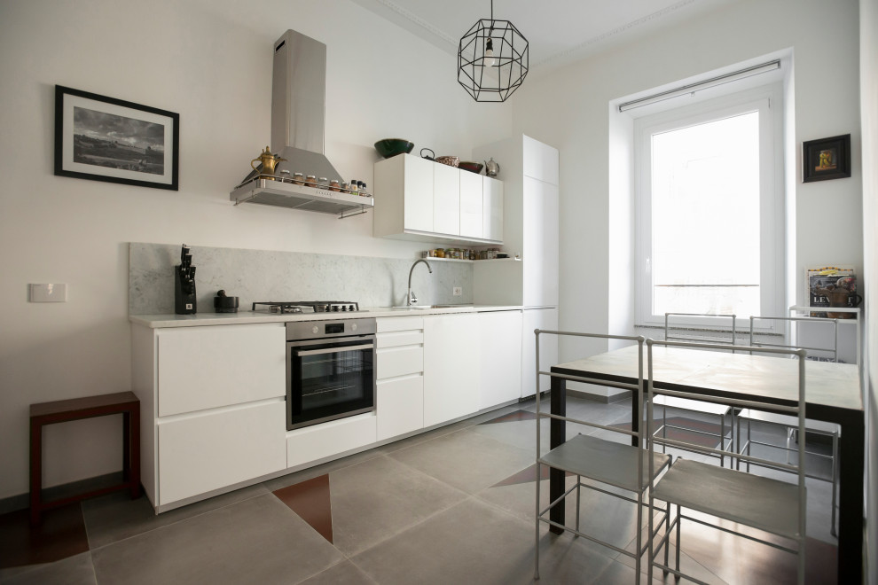 This is an example of a large contemporary single-wall separate kitchen in Rome with a single-bowl sink, flat-panel cabinets, white cabinets, marble benchtops, grey splashback, marble splashback, stainless steel appliances, porcelain floors, multi-coloured floor and grey benchtop.